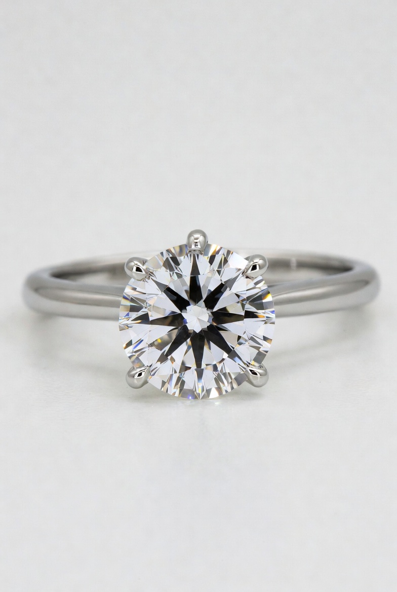 Round brilliant lab-grown diamond solitaire held by six platinum prongs on a thin polished band